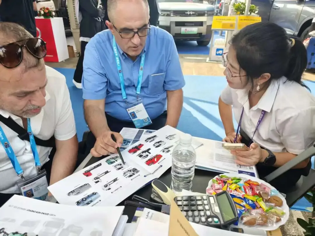 Compradores revisando un catálogo de camiones CLW junto a una calculadora