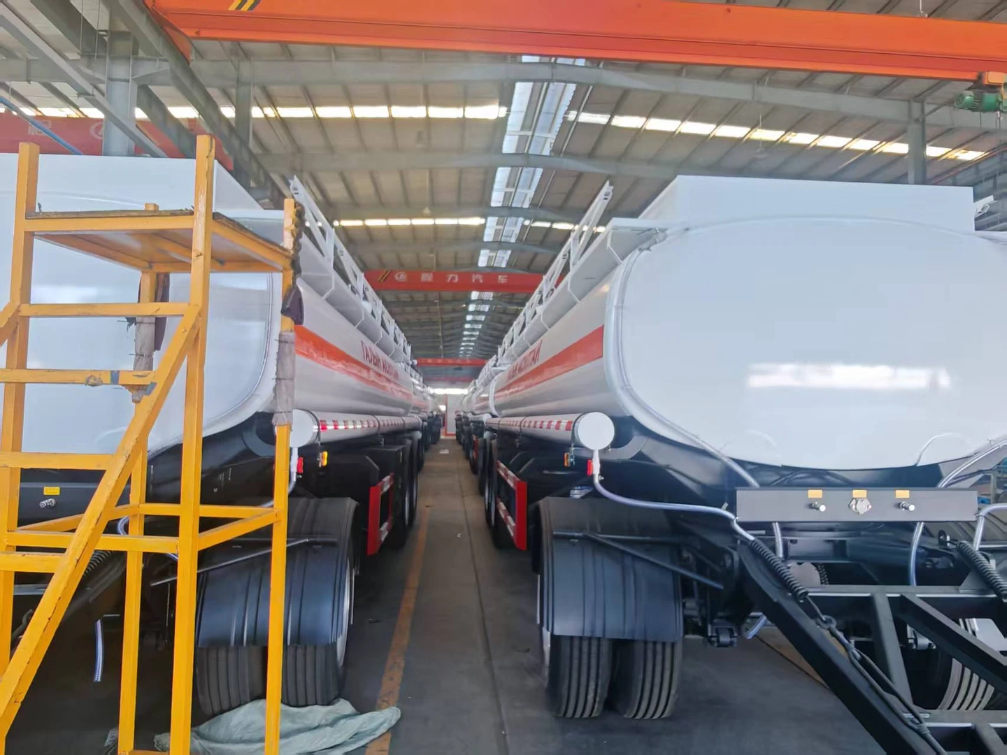 Two rows of finished tank trailers in the factory aisle