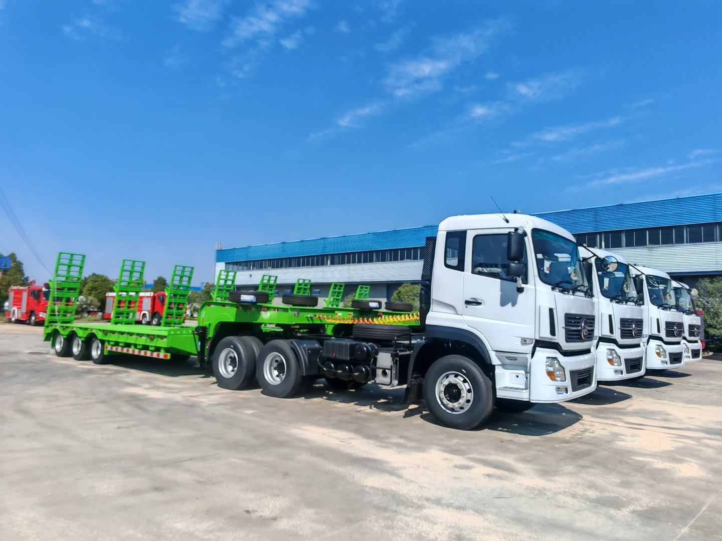 أربع شاحنات قاطرة Dongfeng 6x4 ومقطورات خضراء في ساحة CLW